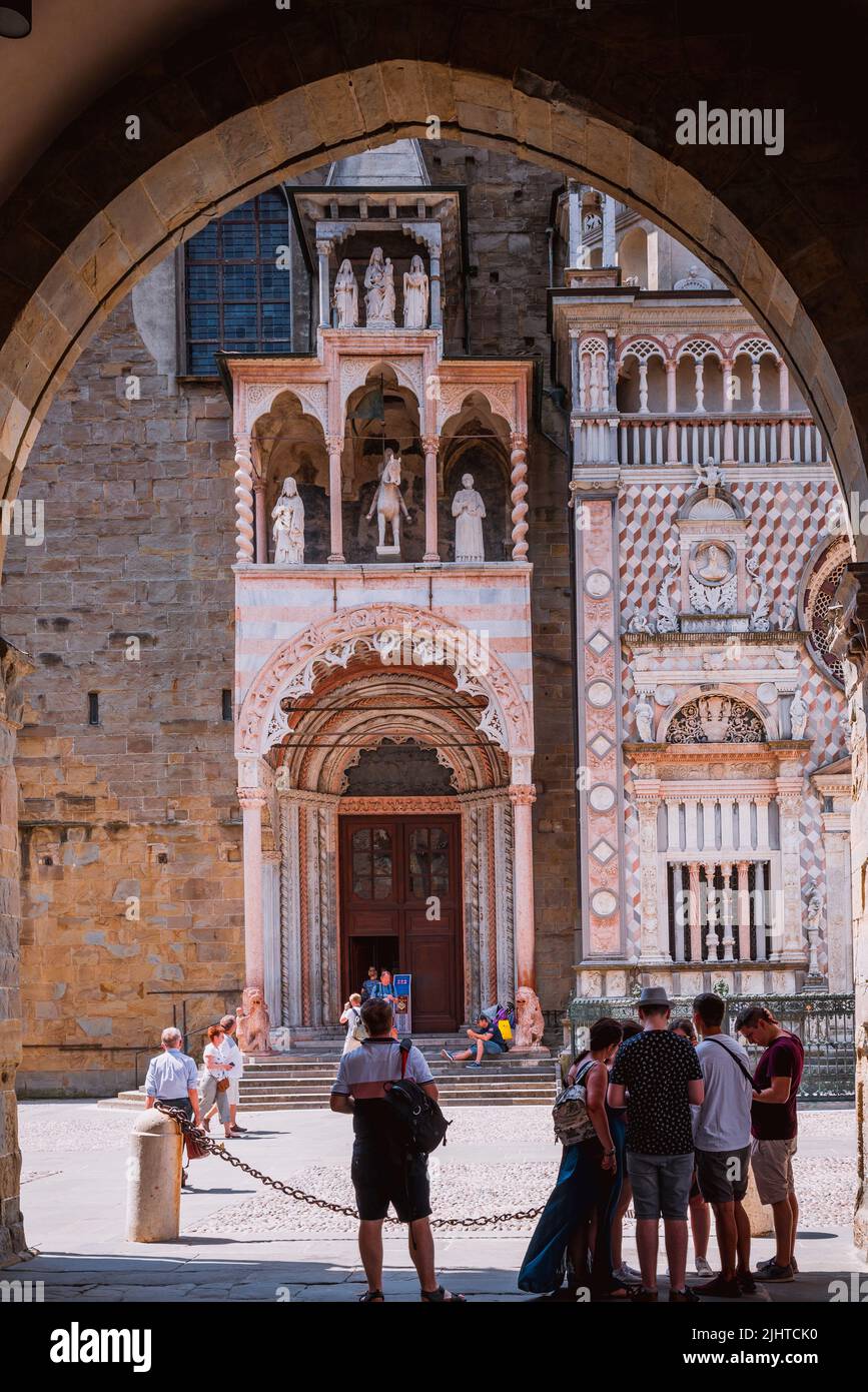 Seen from the arches of the Palazzo della Ragione. Main facade of Basilica of Santa Maria Maggiore is a major church in the upper town of Bergamo. Ber Stock Photo