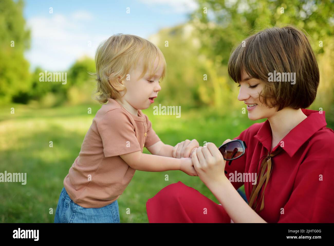 Cute big sister cuddling with her toddler brother. Adorable teenage