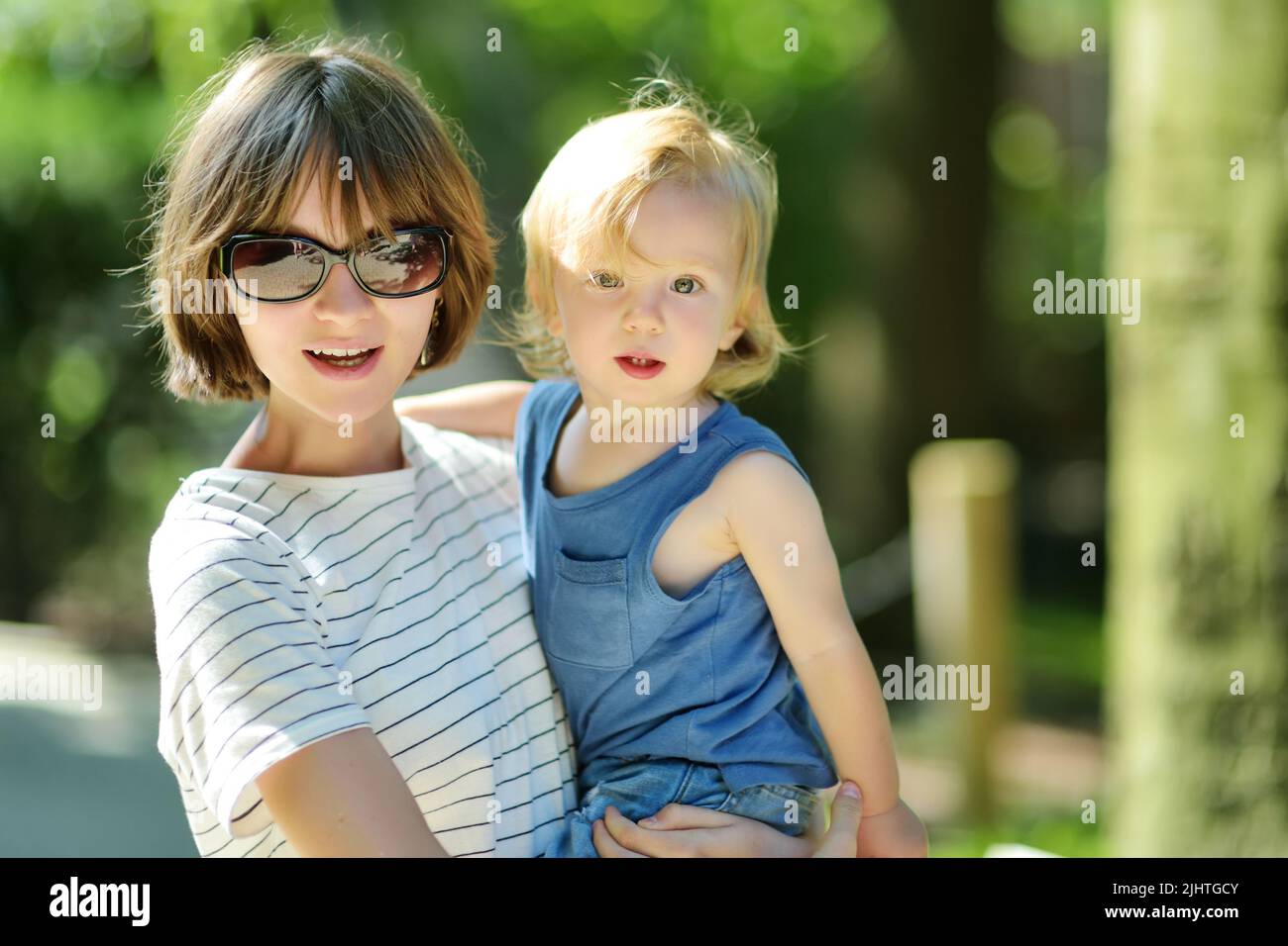Cute big sister cuddling with her toddler brother. Adorable teenage