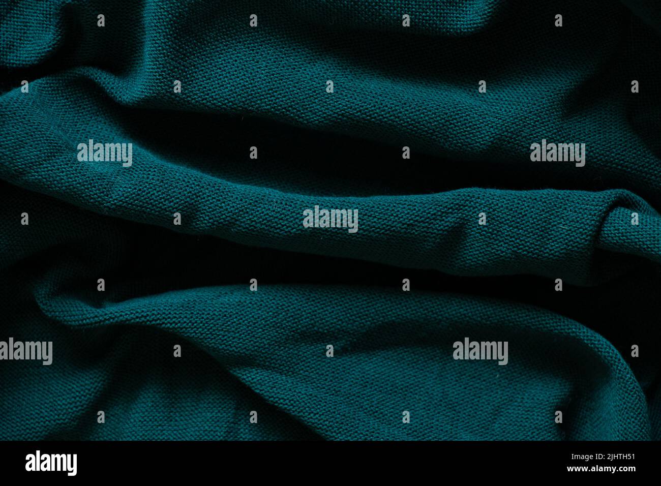 dark green crumpled knitted fabric as background closeup Stock Photo