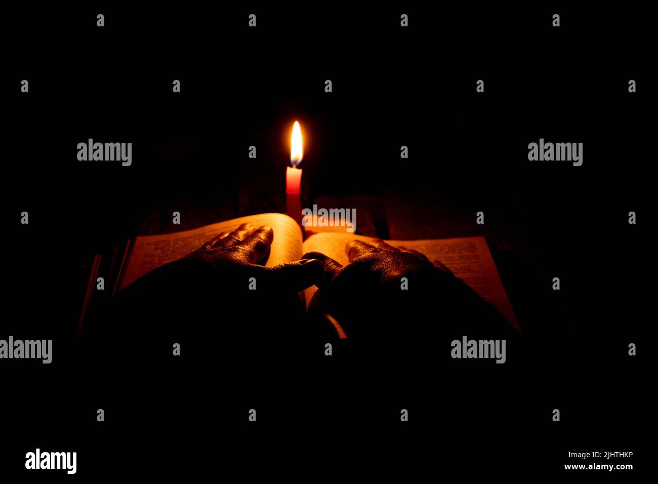 bible lies a candle flame of a candle in the dark, pray a bible, hands