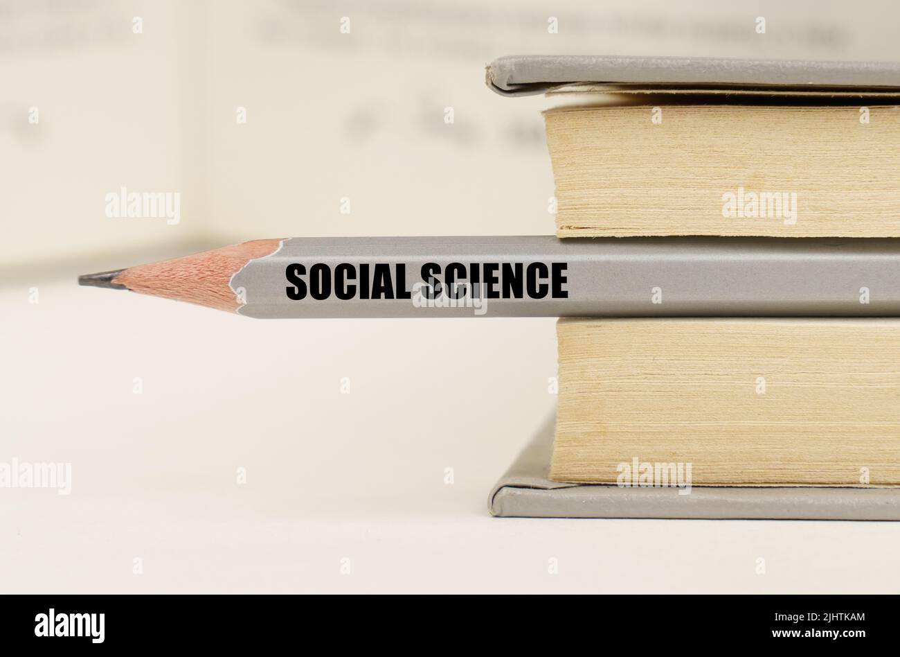 Education concept. In the book between the pages lies a pencil with the inscription - SOCIAL SCIENCE Stock Photo