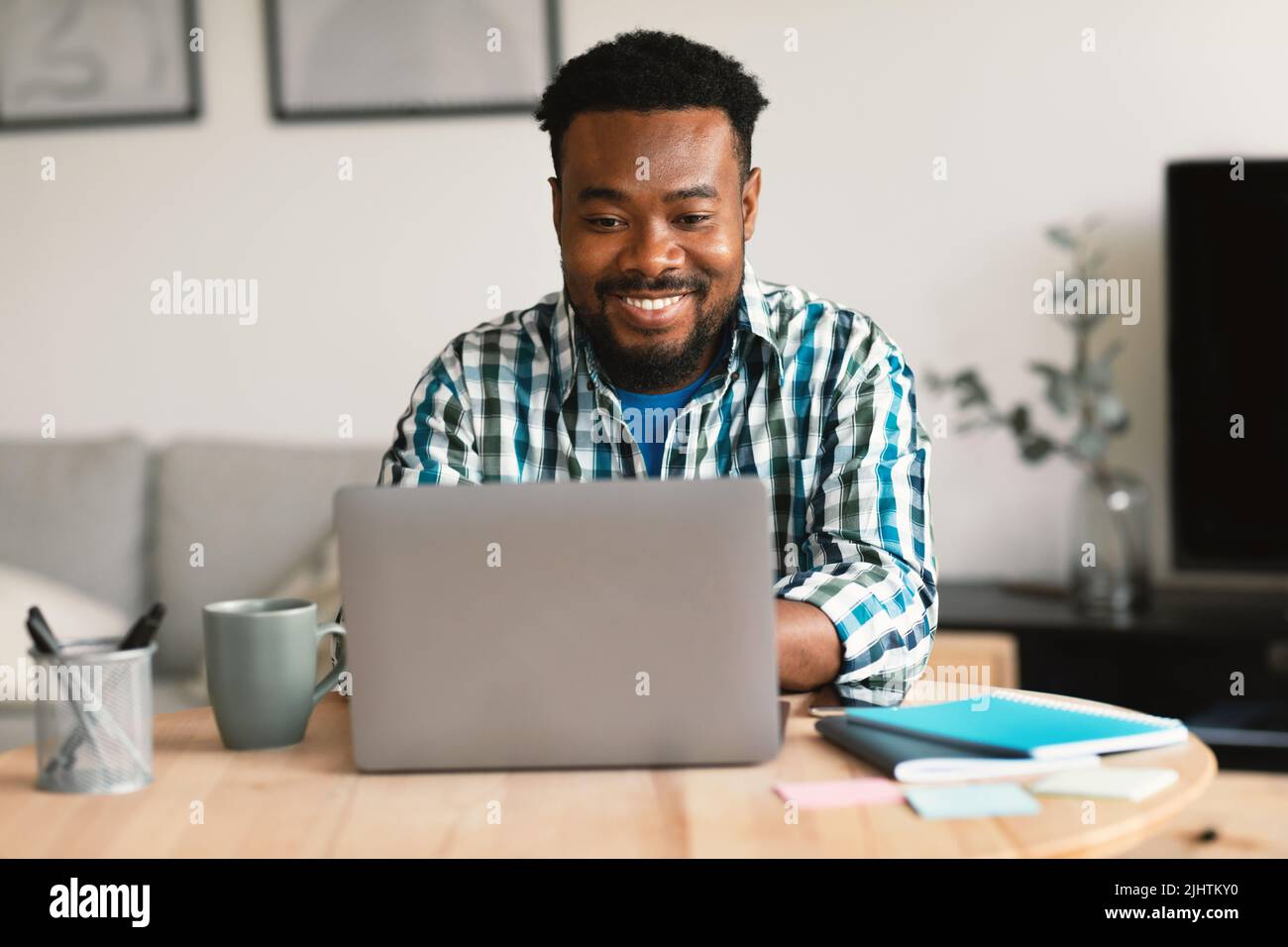 Black Man Using Laptop Working Online Remotely Sitting In Office Stock Photo