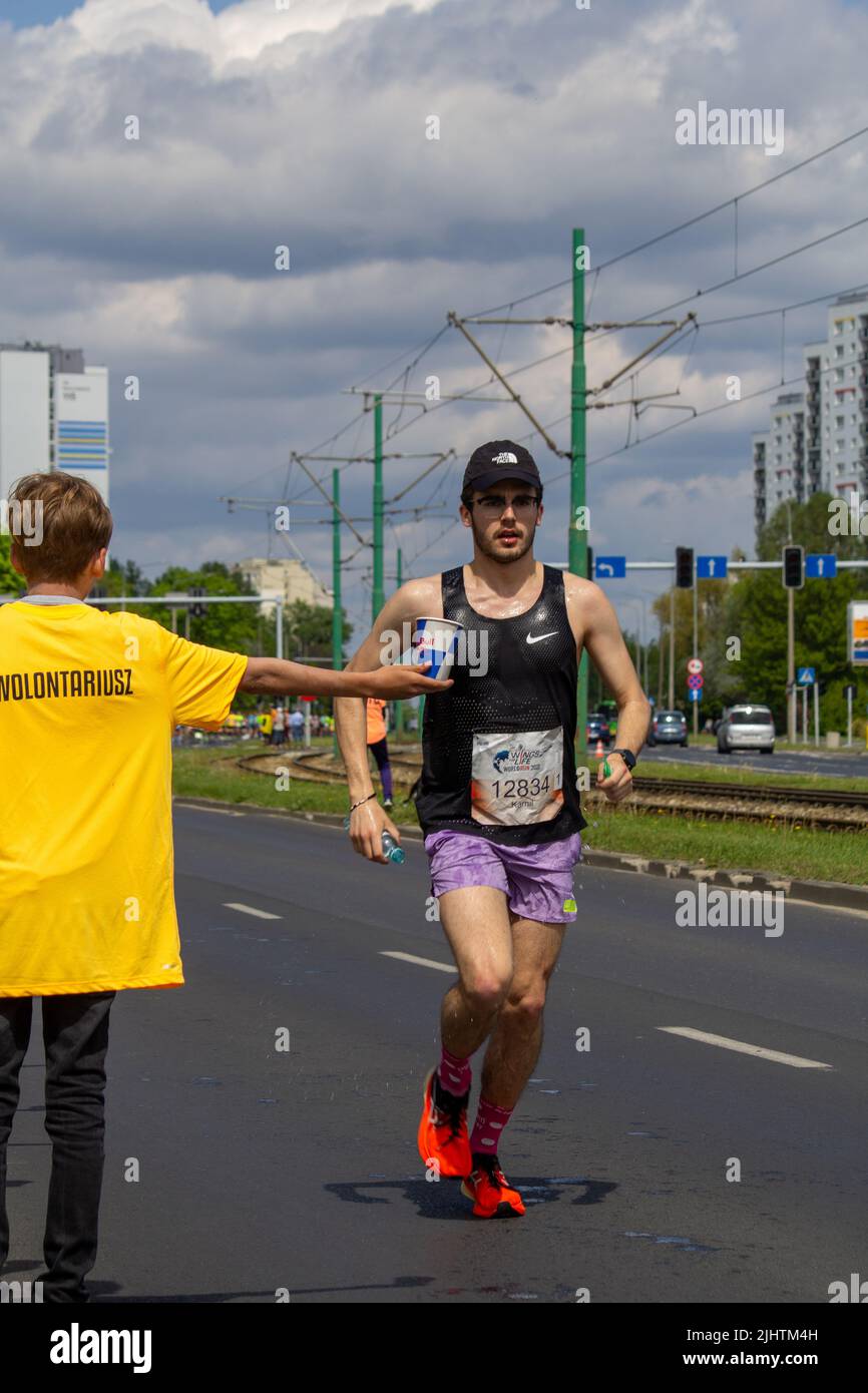 The volunteer offering water to the runner at Wings for Life World Run