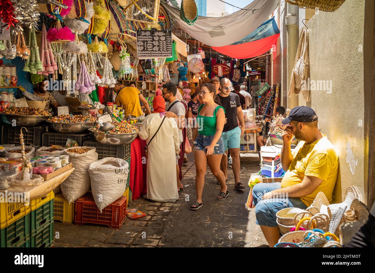 People shop at a sweet stall in the souk at the Medina of Sousse in Tunisia. The ancient medina is a UNESCO world heritage site. Stock Photo