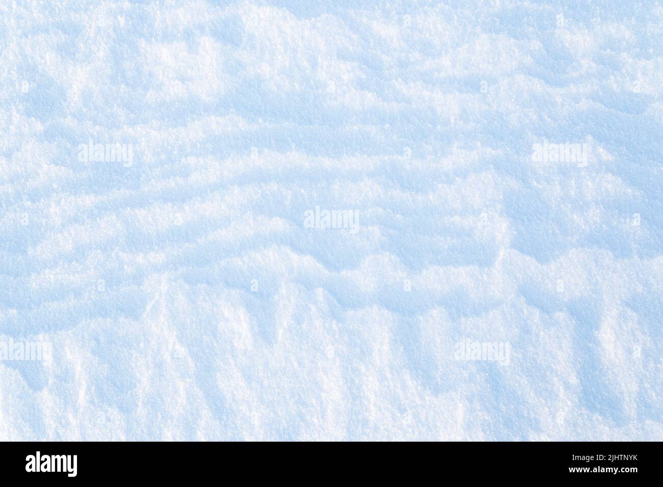 Close-up of fresh snowy land in the winter on a sunny day, viewed from above. Abstract full frame textured background. Copy space. Top view. Stock Photo