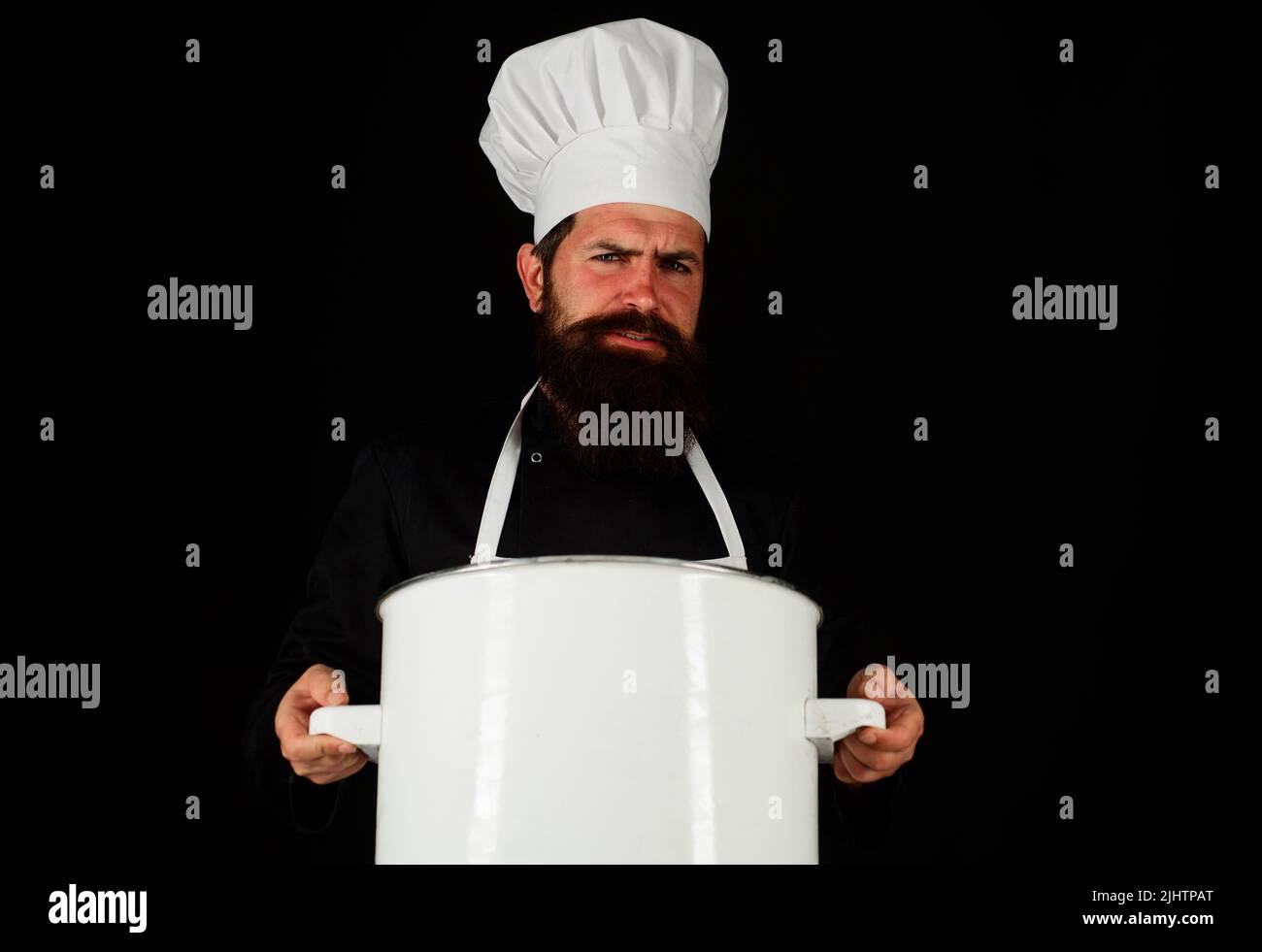 Professional chef with pot or pan. Male Cook in uniform and hat with saucepan. Kitchenware utensil Stock Photo
