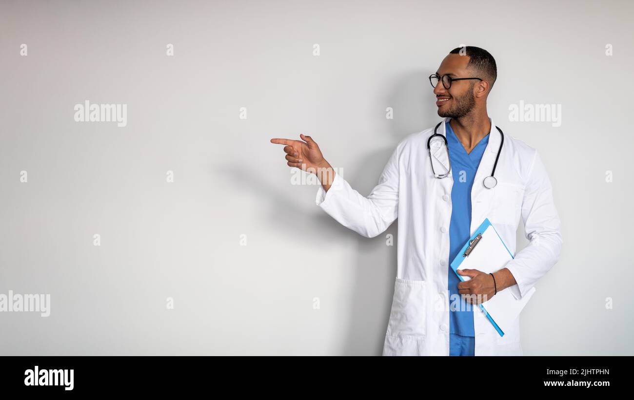Handsome middle eastern doctor pointing at copy space Stock Photo