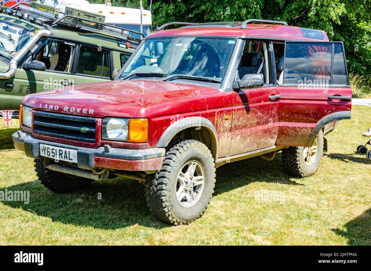 Front view of a 2001 Land Rover Discovery All-terrain vehicle in red with dirt and mud up the side seen here at The Berkshire Motor Show in Reading, Stock Photo
