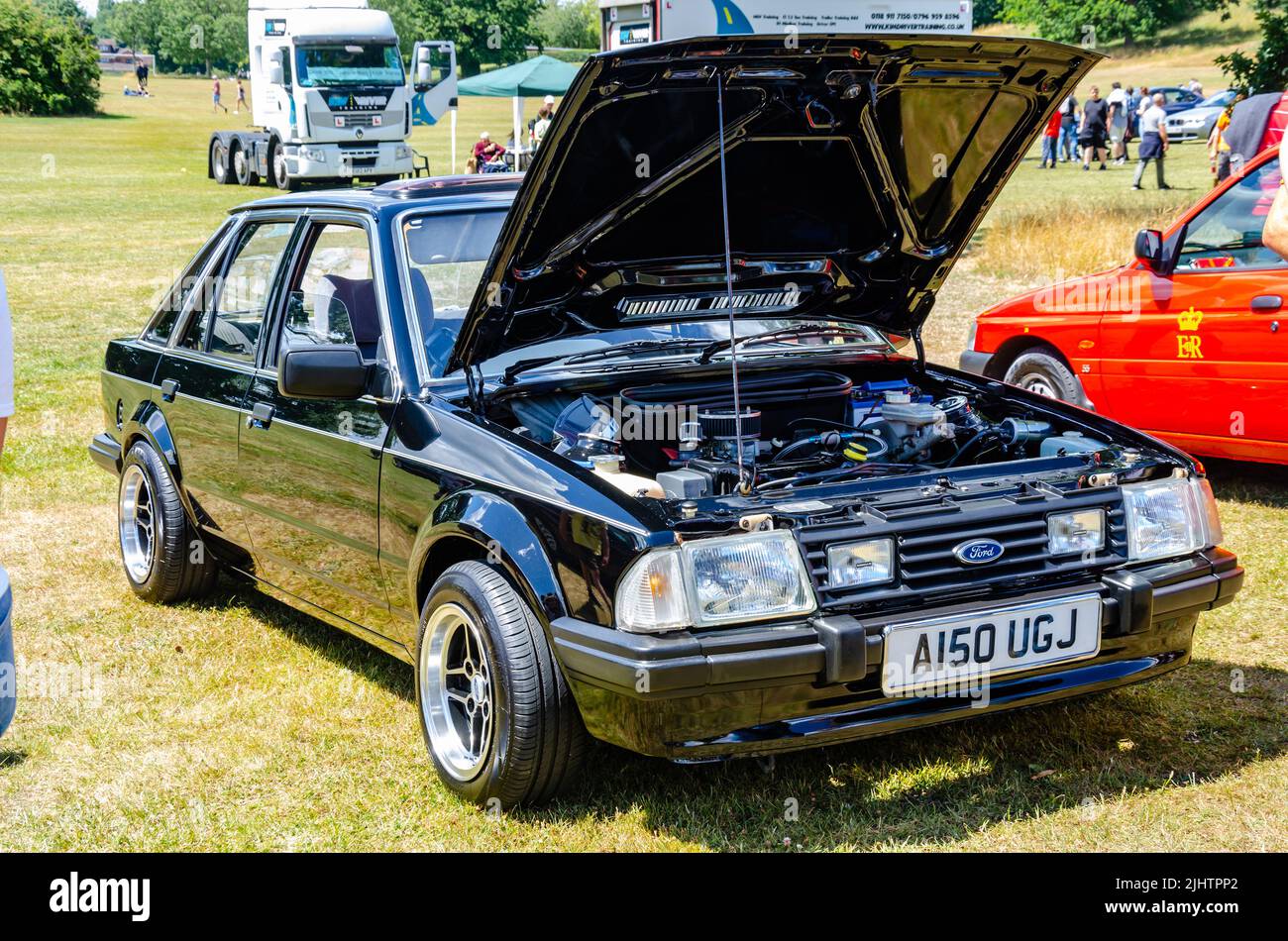 Front view of a 1983 Ford Escort in black with the bonnet up showing the engine at The Berkshire Motor Show in Reading, UK Stock Photo