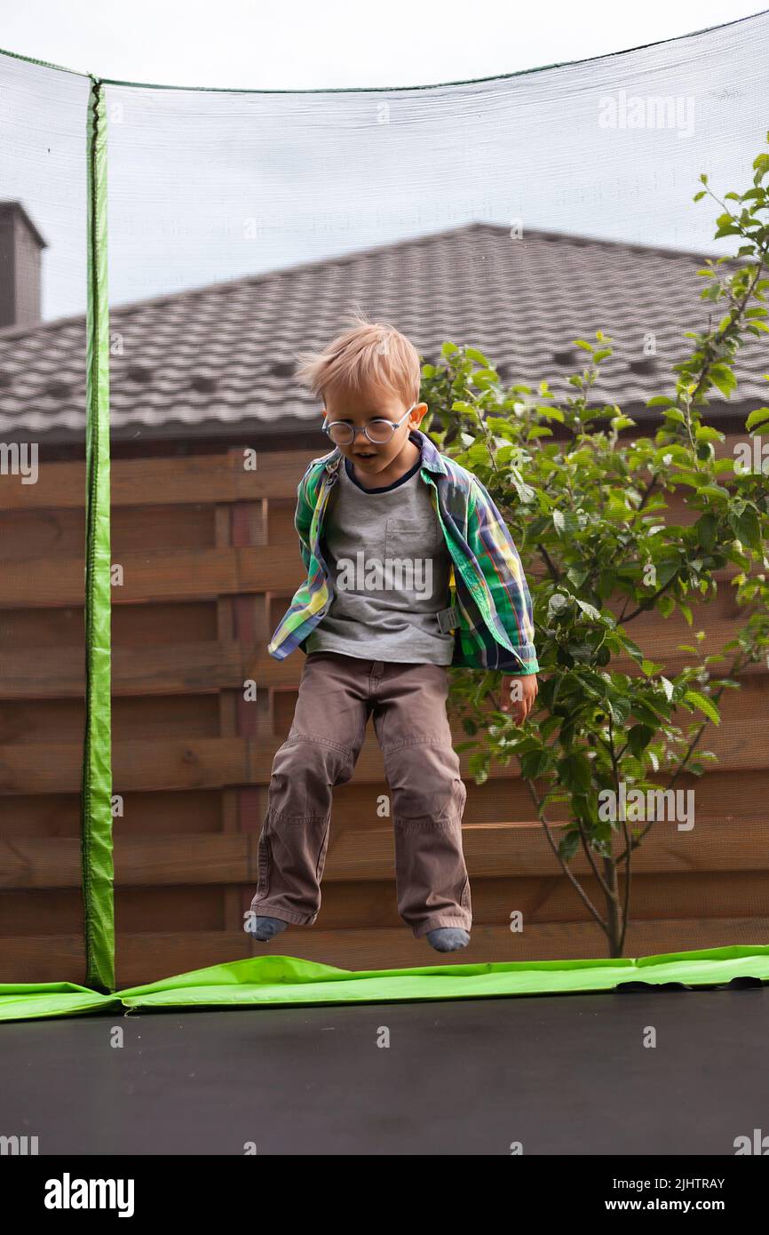Child jumping on trampoline in the backyard Stock Photo Alamy