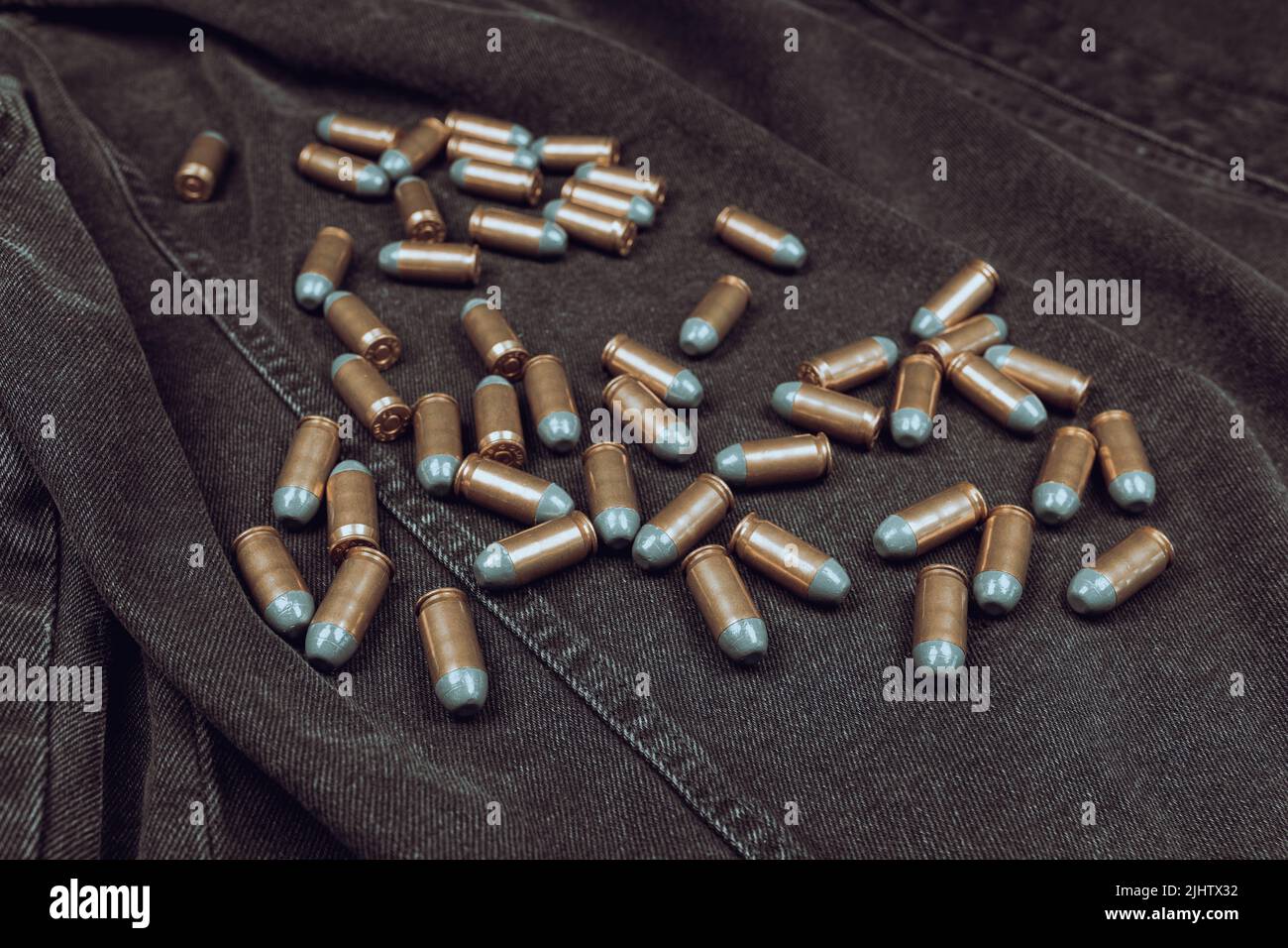 .45 ACP cartridges on a black denim background Stock Photo