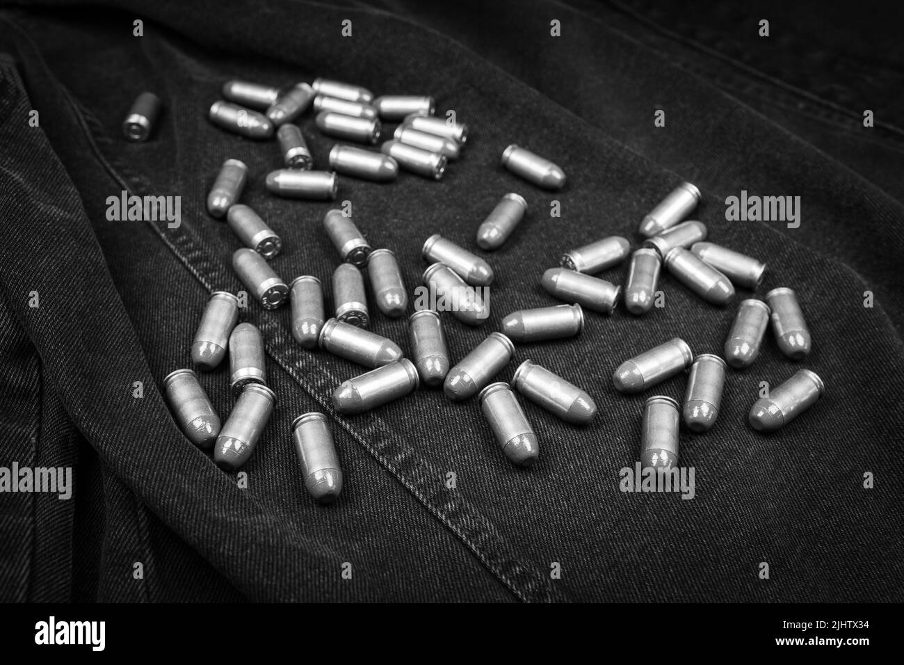 .45 ACP cartridges on a black denim background, monochrome photo Stock Photo