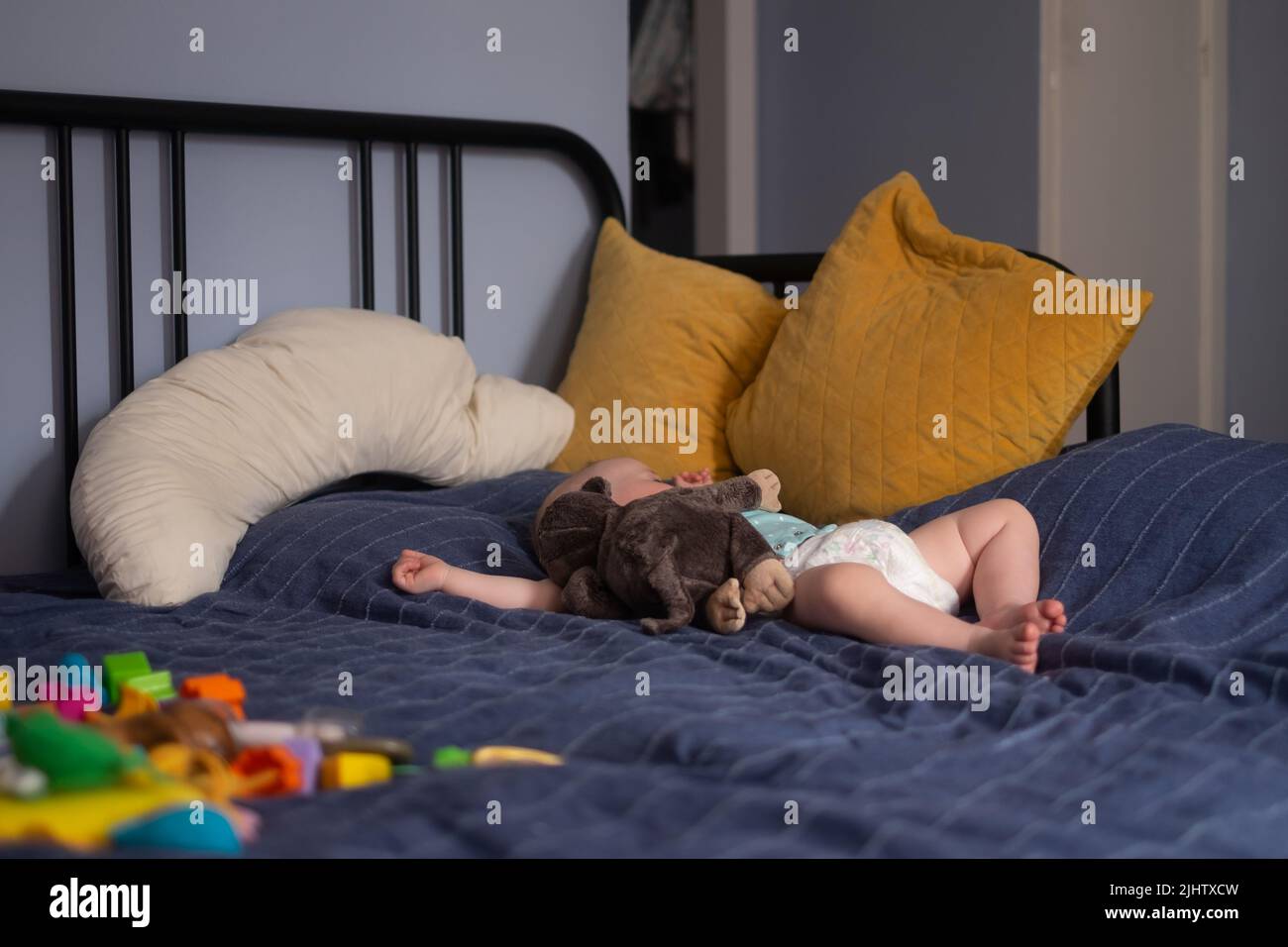 Cute little baby girl with a toy sleeping on bed at home Stock Photo