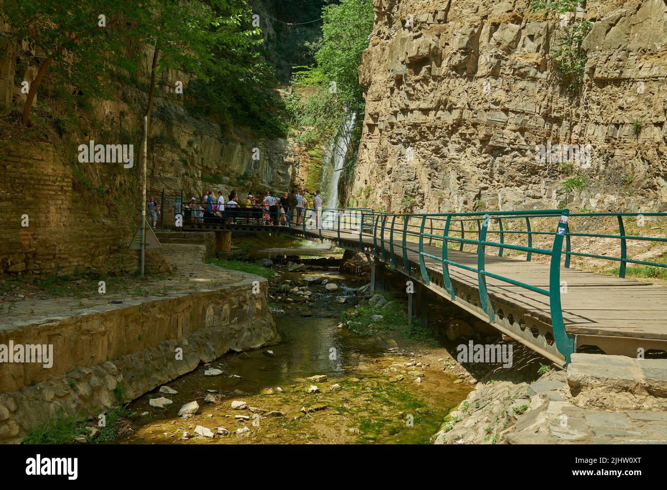 Leghvtakhevi waterfall and the natural spring in Abanotubani district , Old Tbilisi, Georgia day light view with tourists walking Stock Photo