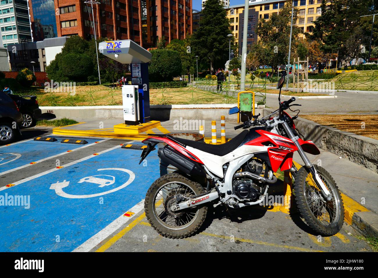 La Paz, Bolivia. A Rimexico RX250 motorbike parked next to an electric vehicle charging station in Plaza Bolivia, Sopocachi district. Bolivia still has very few electric vehicles but the state electricity company ENDE (Empresa Nacional de Electricidad) Corporation has been installing charging points in the main cities Stock Photo