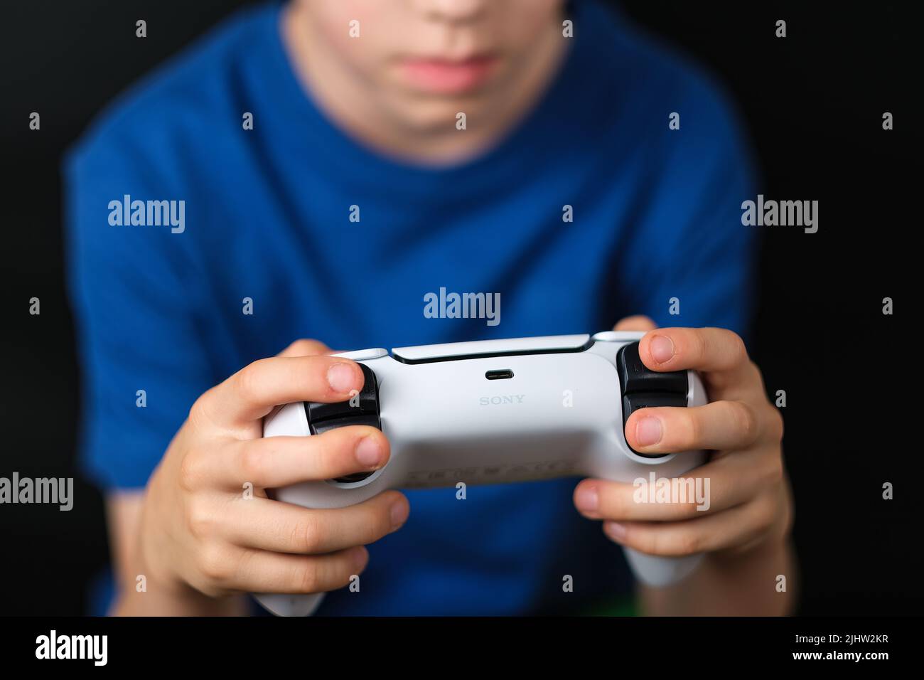 SONY logotype seen on PS5 DualSense controller which is seen in hands of a child. Concept for gaming. Stafford, United Kingdom, July 19, 2022 Stock Photo