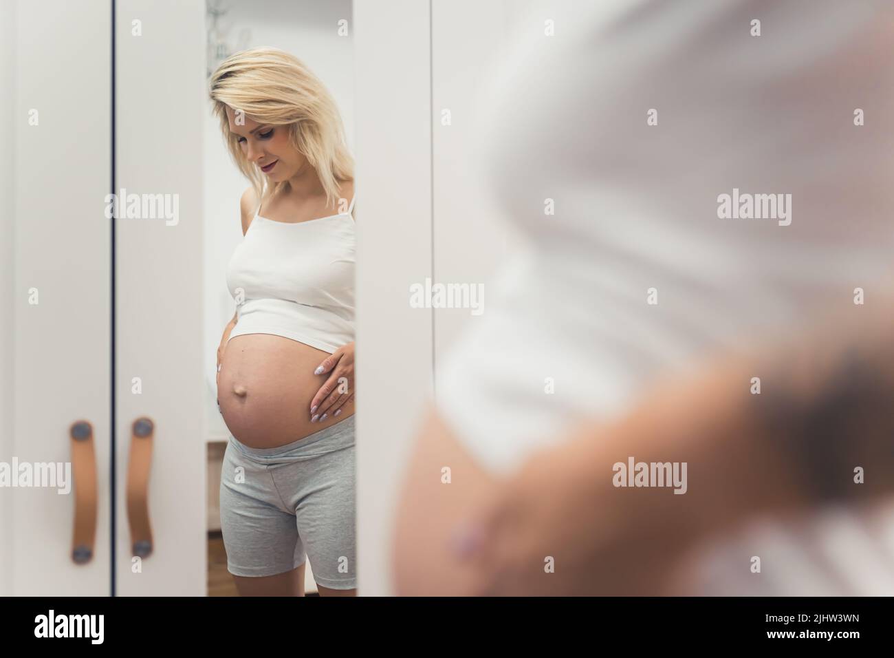 pregnant woman posing in front of the mirror, pregnancy concept. High quality photo Stock Photo