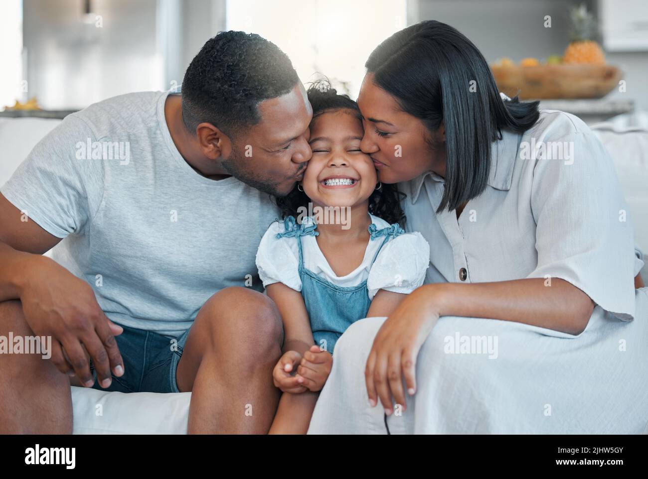 Dont forget to shine. a young family bonding with their daughter on the sofa at home. Stock Photo