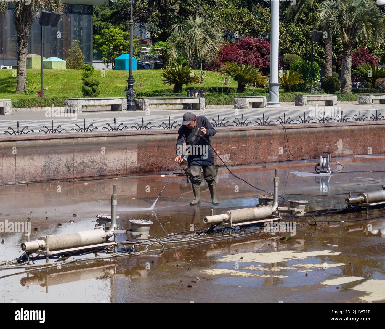 Batumi, 05.23.2022 worker cleans the mechanism of the fountain