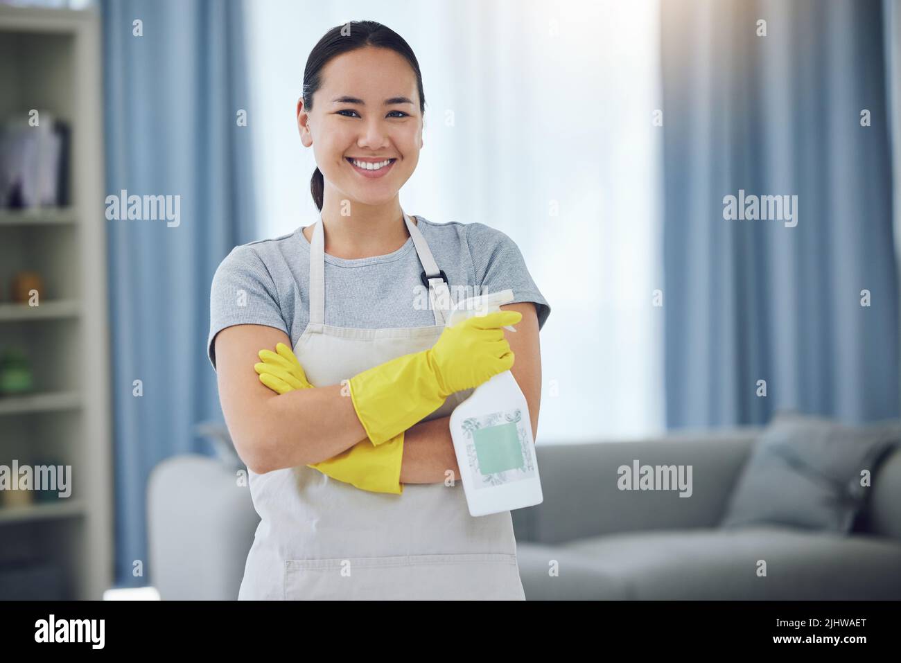 Ready to clean. a young woman standing with her arms crossed while ...
