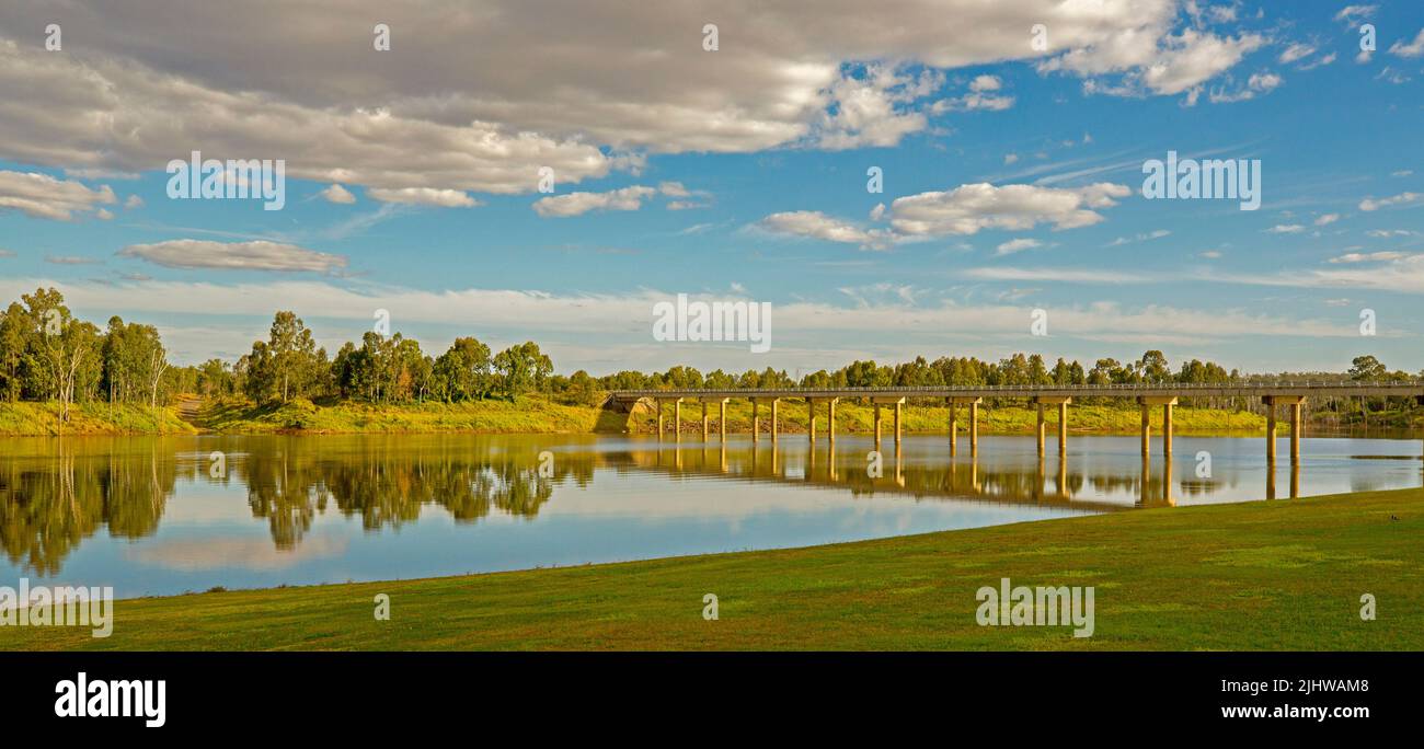 Stunning panoramic view of calm waters of Burnett River / Paradise dam under blue sky with high bridge crossing water at Mingo Crossing in Australia Stock Photo