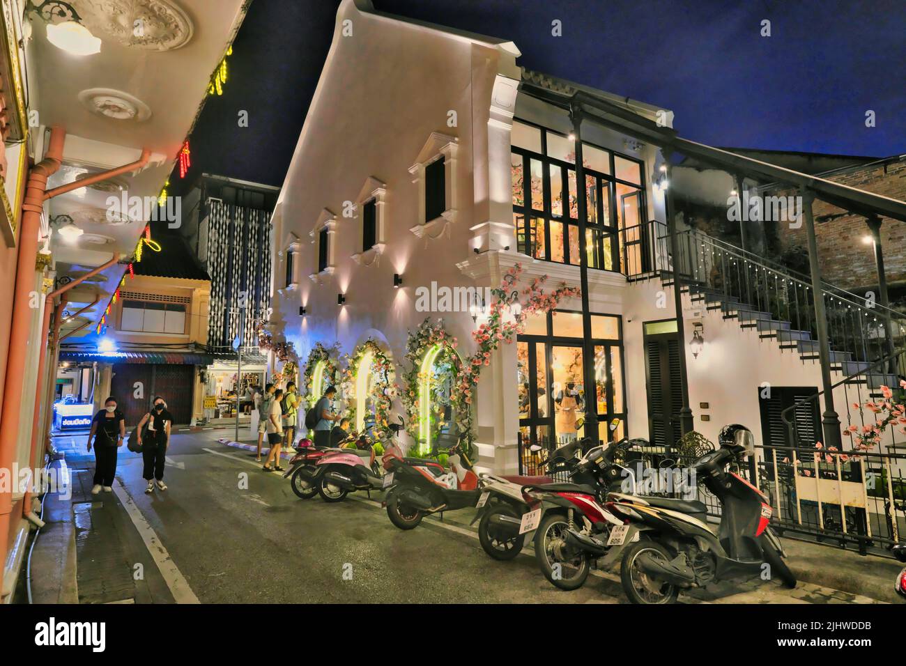 Dusk falls on picturesque Soi Rommanee (Rommani) in the Old Town heritage area of Phuket Town, Thailand; the house on the right: Aung Ku Cafe Stock Photo