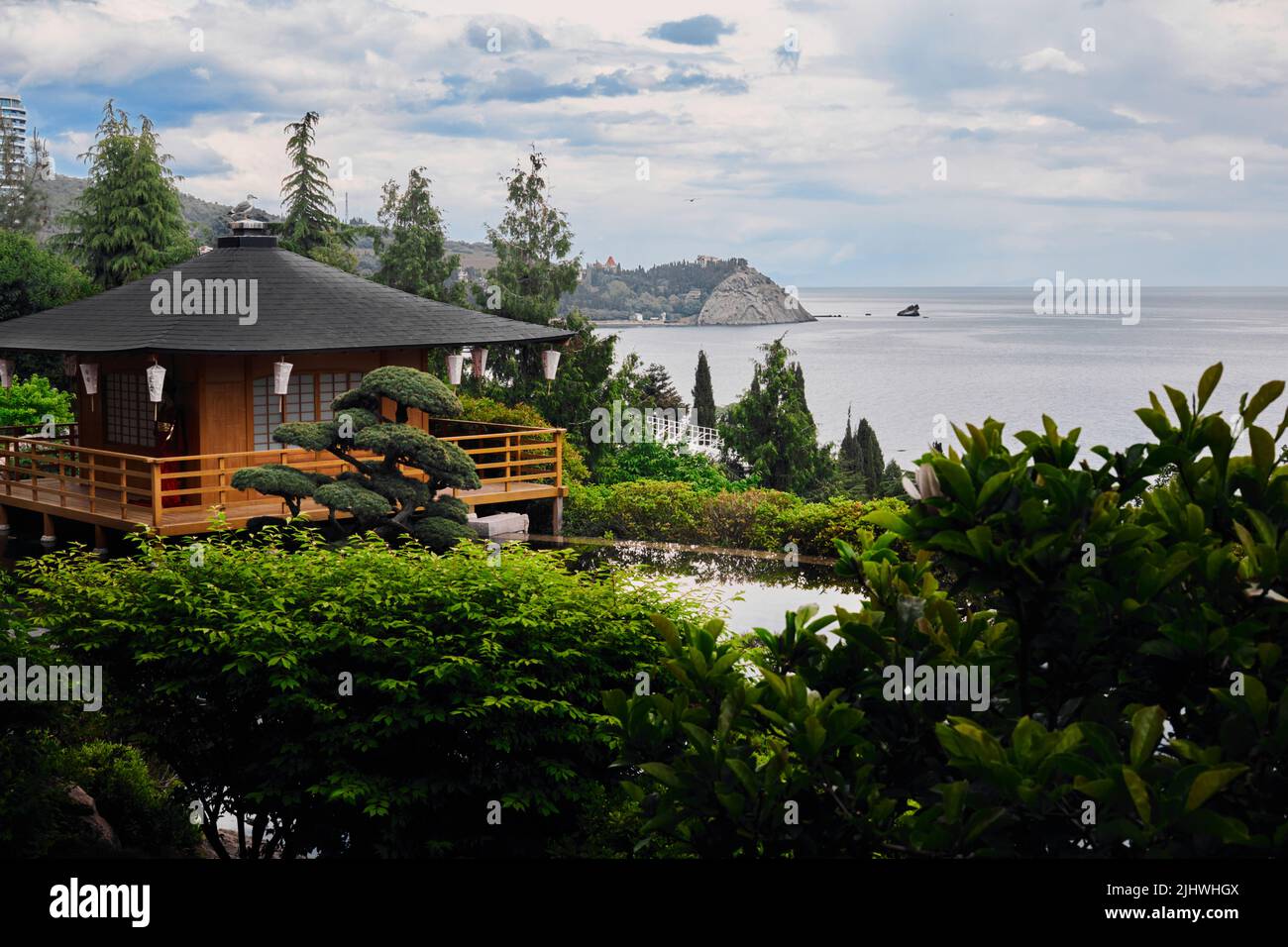 Japanese-style house by the sea. View of the sea, rocks and forest. Front view. Stock Photo