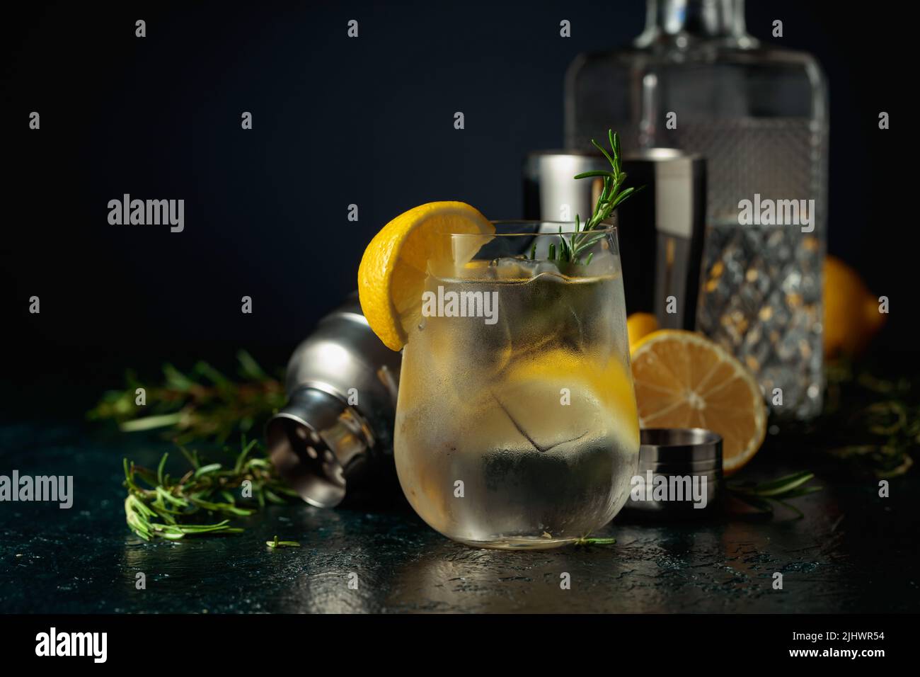 Cocktail gin tonic with ice, lemon, and rosemary. A refreshing drink