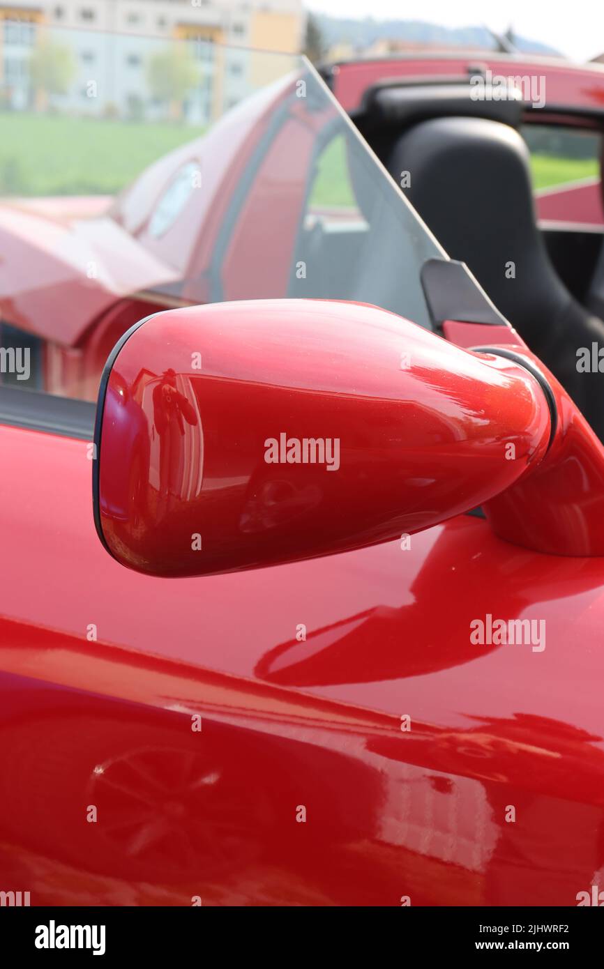 A closeup of a side mirror of a red luxury car Stock Photo - Alamy
