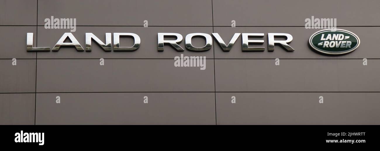 Luxury brand Land Rover logo on wall facade. Luxury Car dealership in Bologna, Italy Stock Photo
