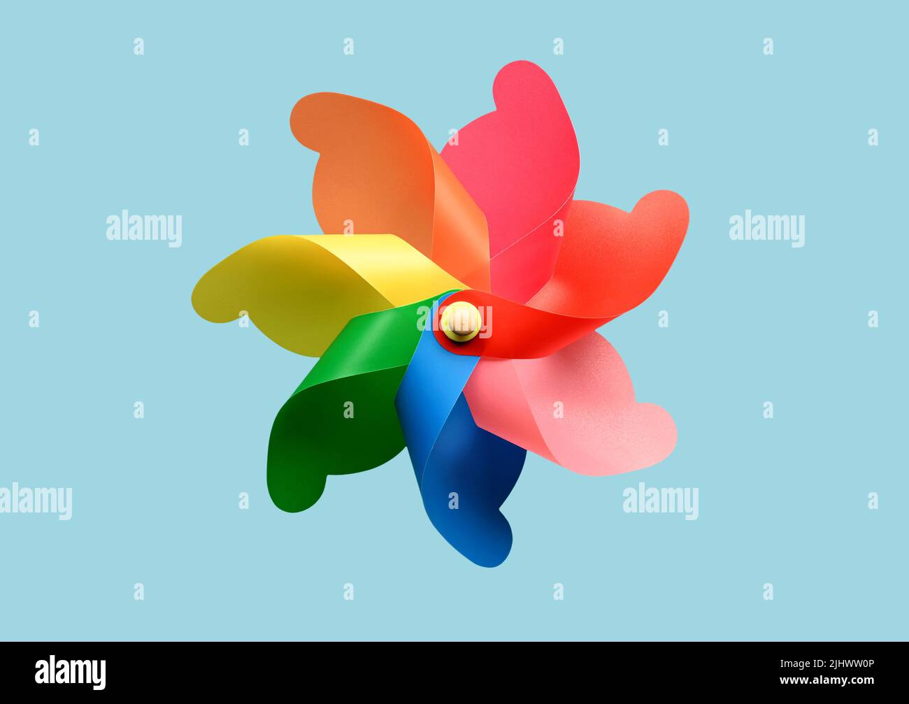 Bright pinwheel toy with colorful curls whirling against blue background in summer Stock Photo