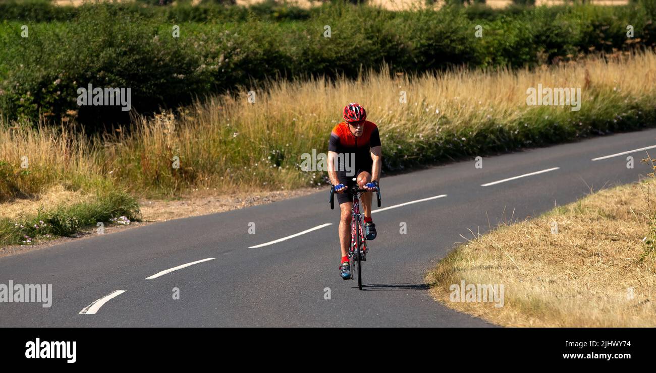 Lycra clad cyclist on a country road Stock Photo