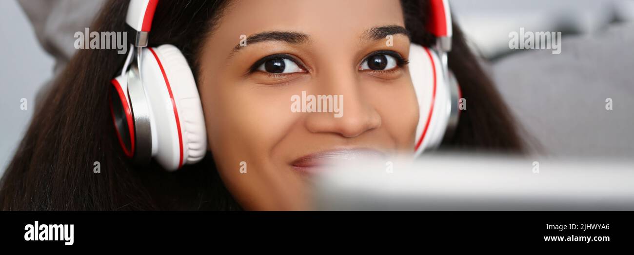 Latino american young woman wear headset and watch movie or take online class Stock Photo