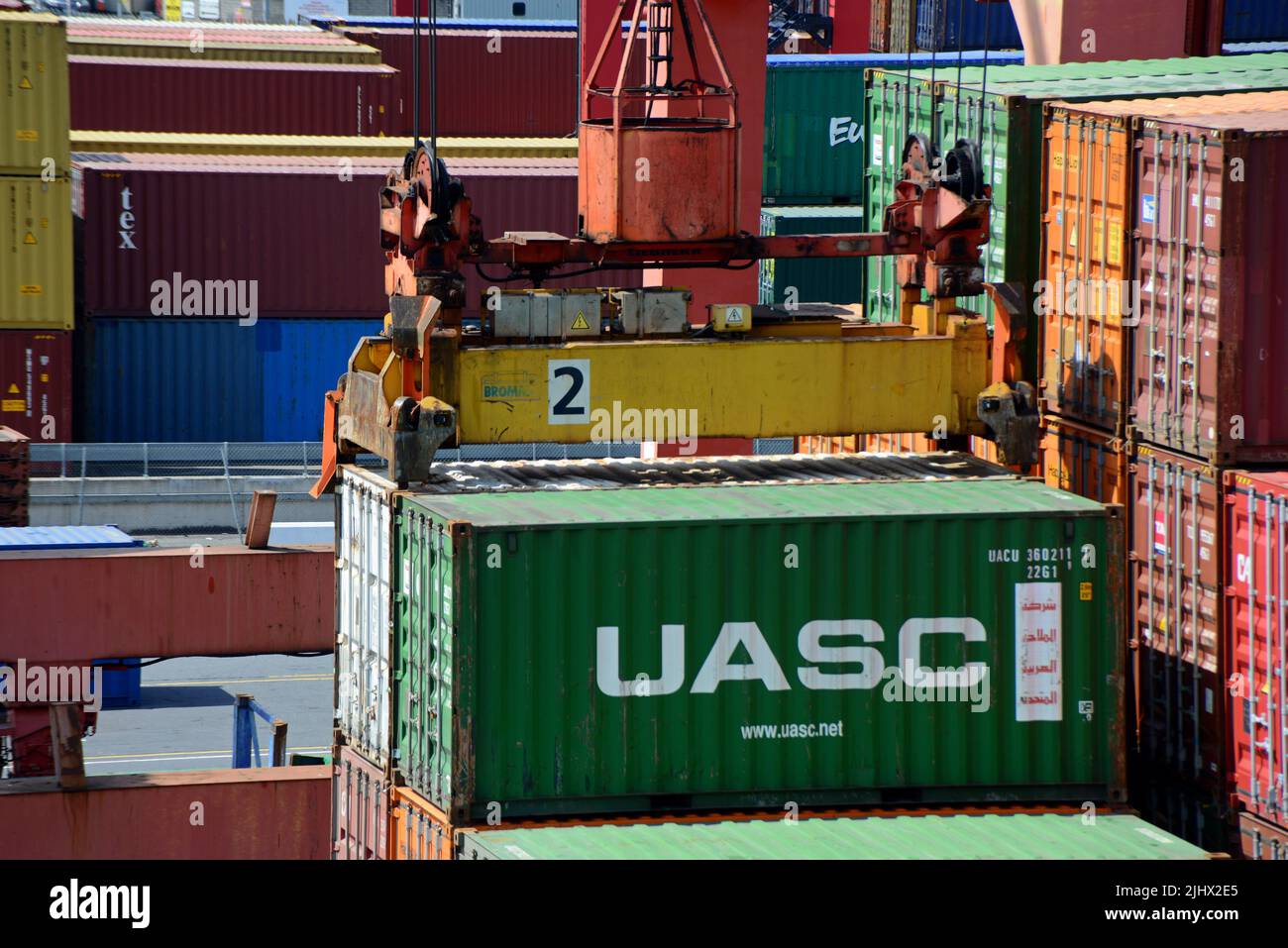 Container crane picking up a 20ft shipping container off a vessel in