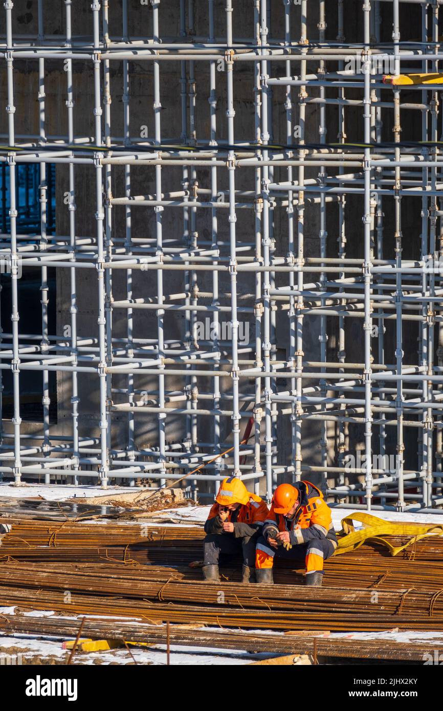 Unrecognizable builders using smartphones during break Stock Photo