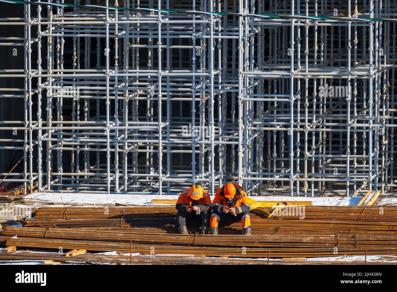 Unrecognizable builders using smartphones during break Stock Photo