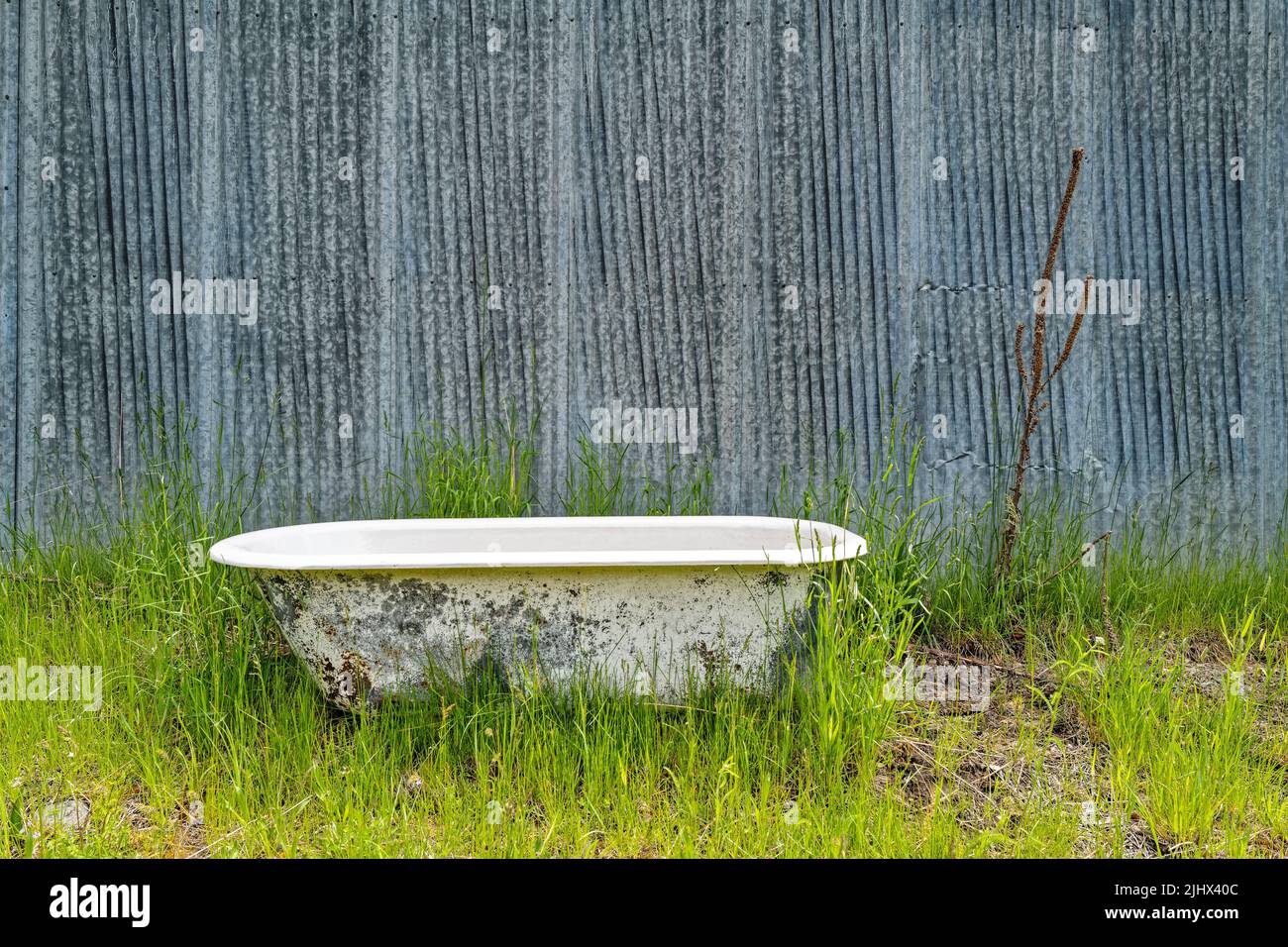Old bathtub outside the wall of a metal building Stock Photo Alamy