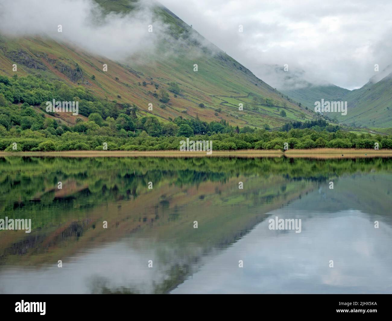 View across Brotherswater lake on a misty morning with Kirkstone Pass in the background, Cumbria, England Stock Photo