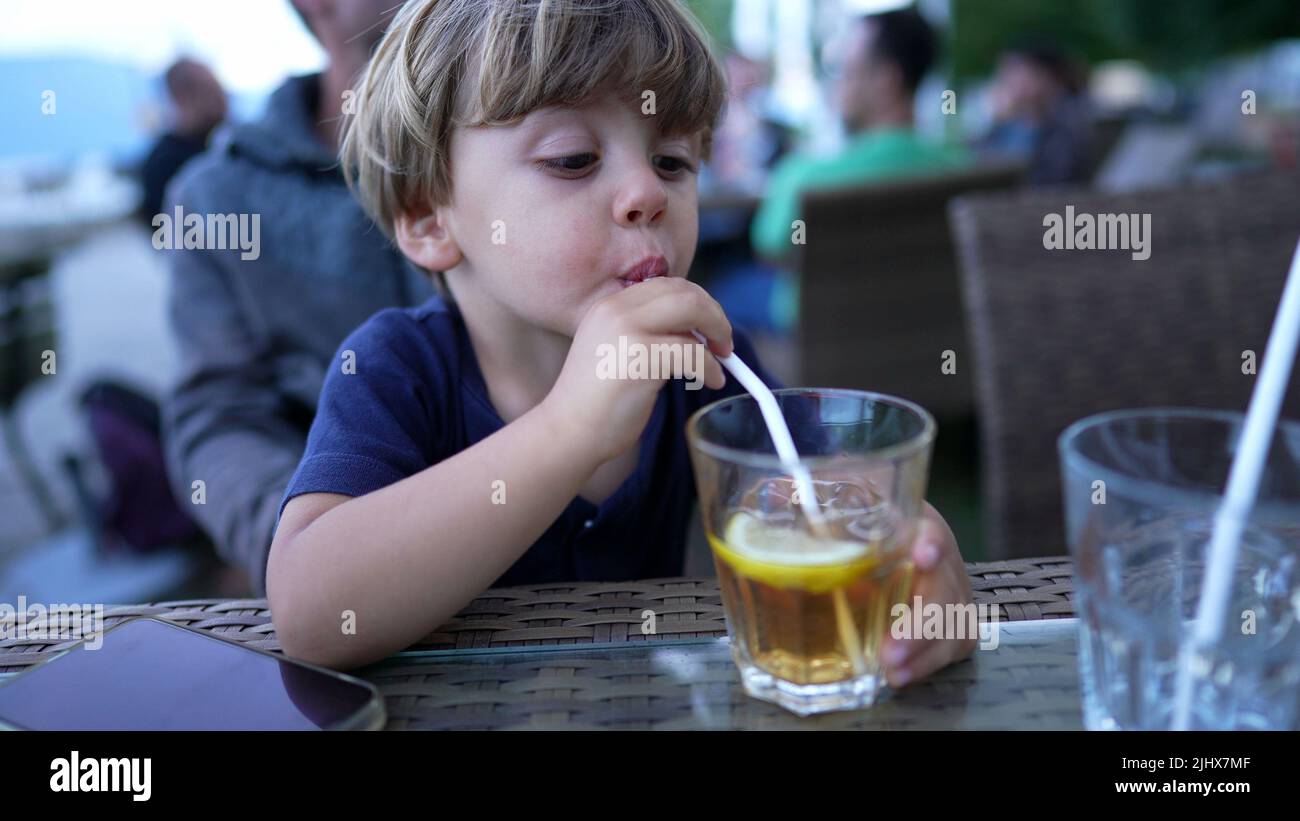 Child drinking from straw juice Stock Photo - Alamy