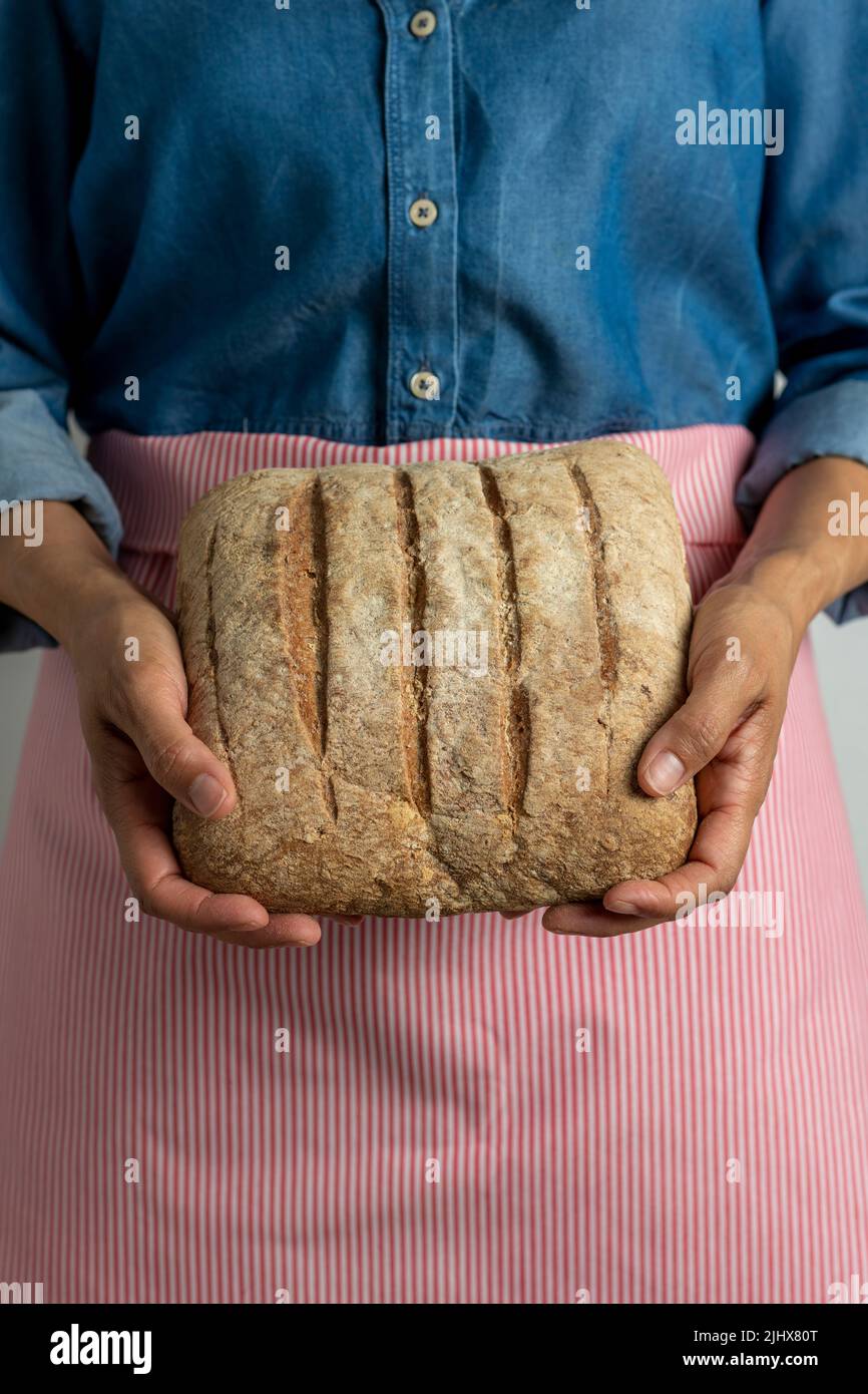 Young woman holding freshly homemade rustic bread - stock photo Stock Photo