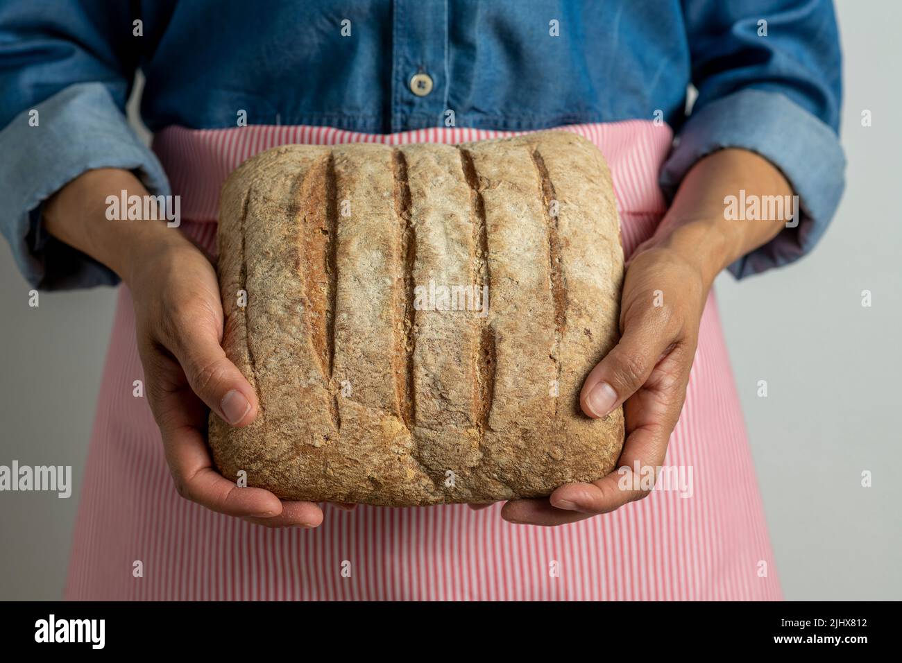 Young woman holding freshly homemade rustic bread - stock photo Stock Photo