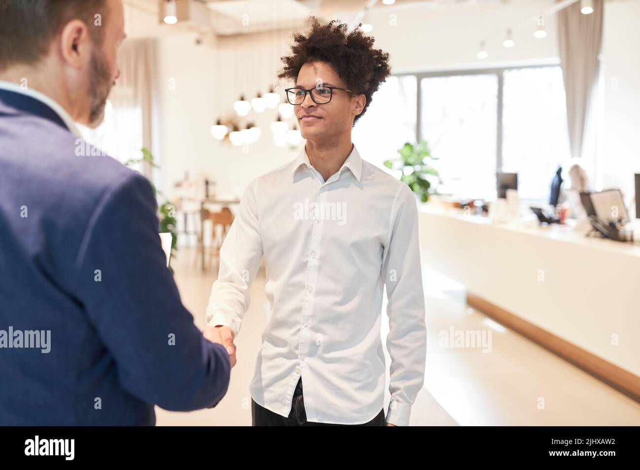 Young business man and manager shaking hands for greeting and partnership Stock Photo