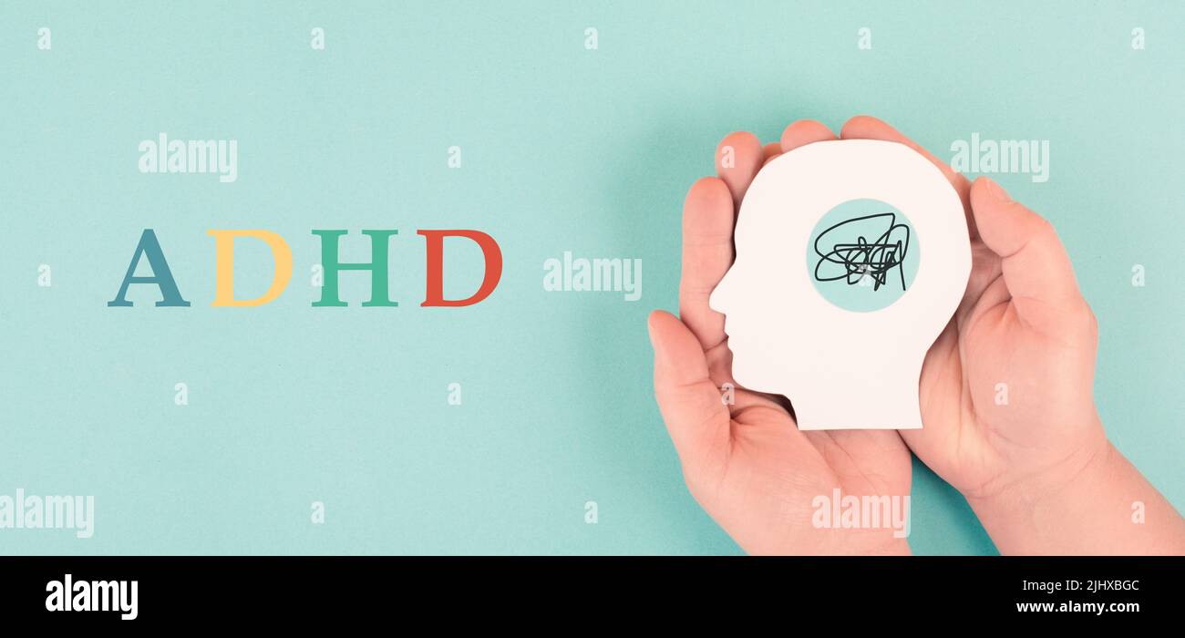 Hands holding a silhouette of a human head, attention deficit hyperactivity disorder, ADHD symptom, mental health Stock Photo