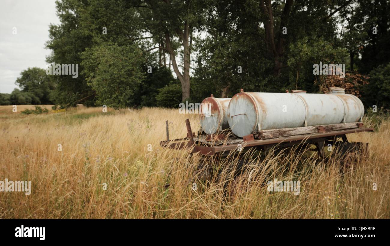 15 July 2022, Lower Saxony, Brunswick: An old, rust-covered water truck stands in a fallow pasture along the Oker River in the Veltenhof district. Photo: Stefan Jaitner/dpa Stock Photo