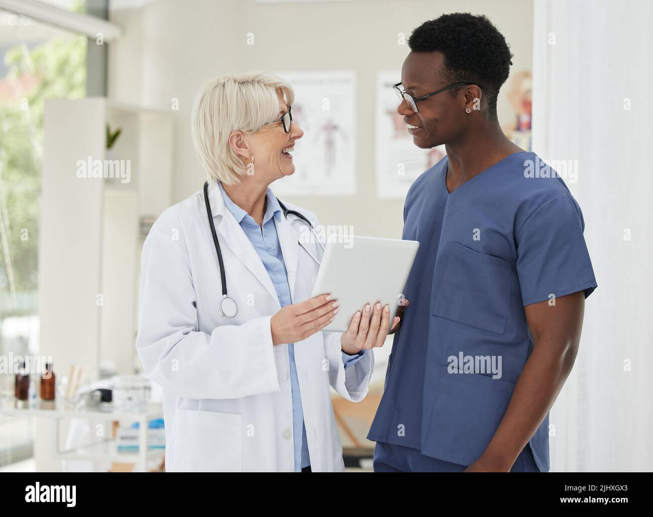We need to come up with a treatment plan. two medical doctors having a discussion while using a digital tablet. Stock Photo