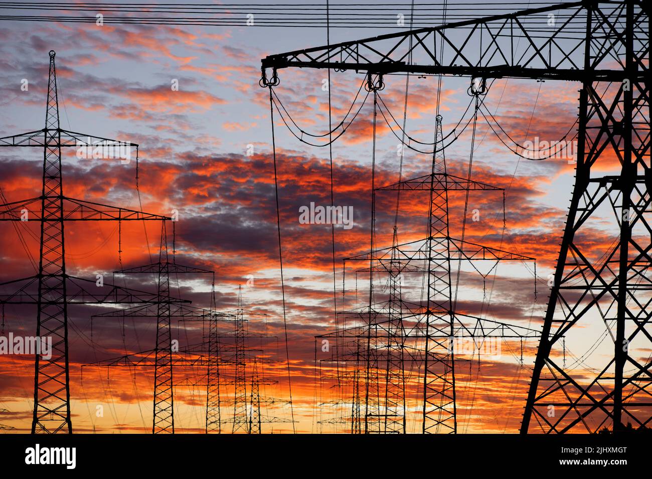 Viele Strommasten und Stromleitungen vor Himmel Stock Photo