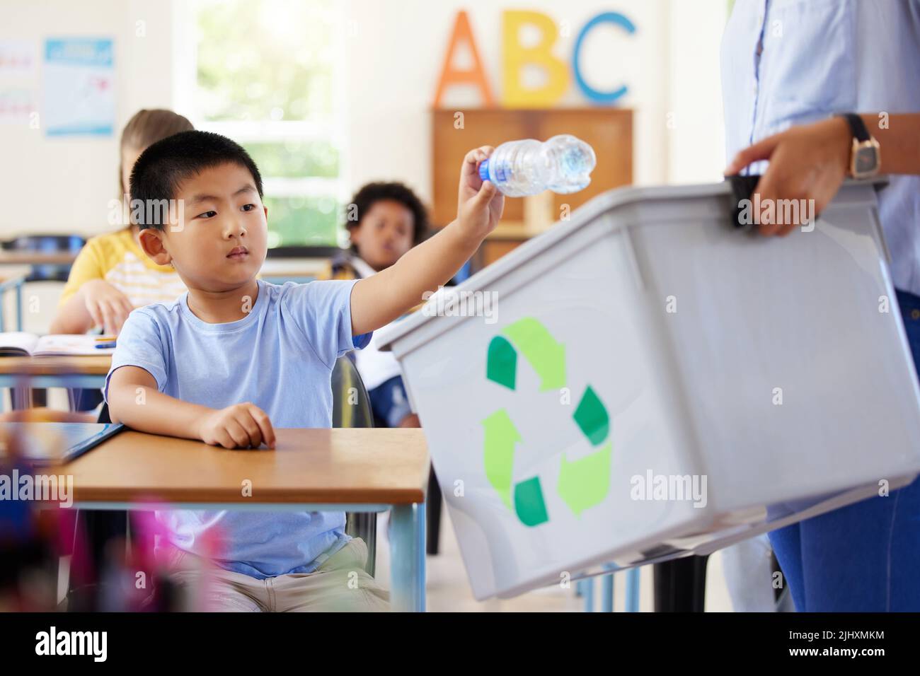 Always eager to answer. a leaner and teaching recycling in a classroom. Stock Photo