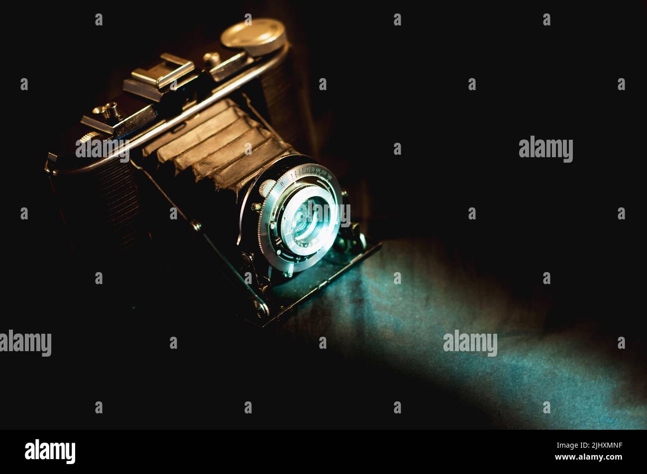 Vintage analog film camera with a bright cold ray of light. Vintage photographic equipment Stock