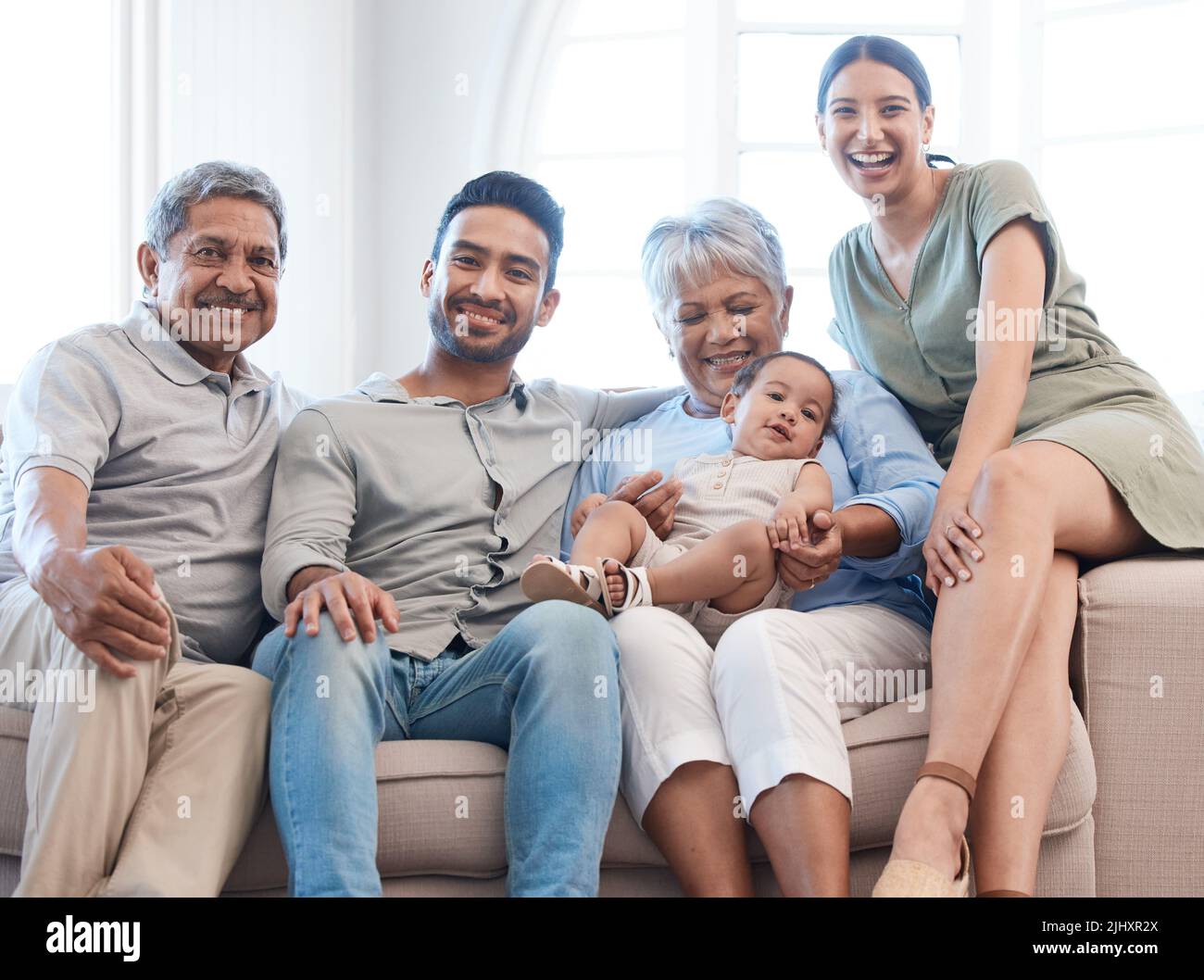 Shielded, happy, loved. a family spending time together on a sofa at home. Stock Photo